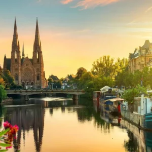 Canal de la petite France avec maisons à colombages traditionnelles et vue sur la cathédrale de Strasbourg.